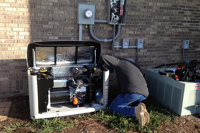 Technician Performing Generator Installation Next to Electrical Panel Outside House