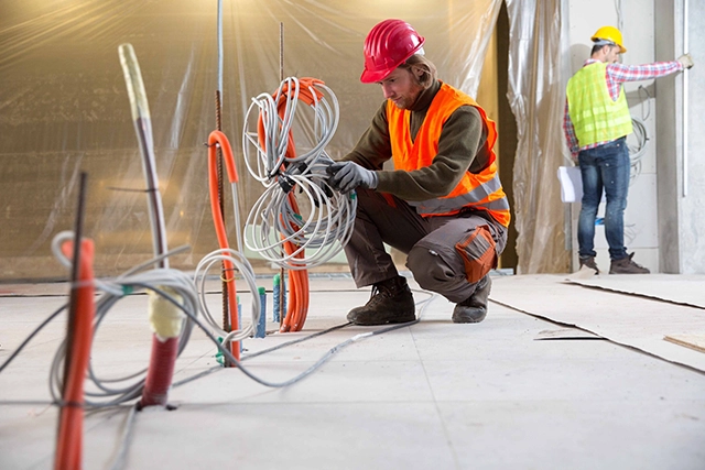 Electrician Lancaster, CA Organizing Cables at Construction Site in Safety Gear